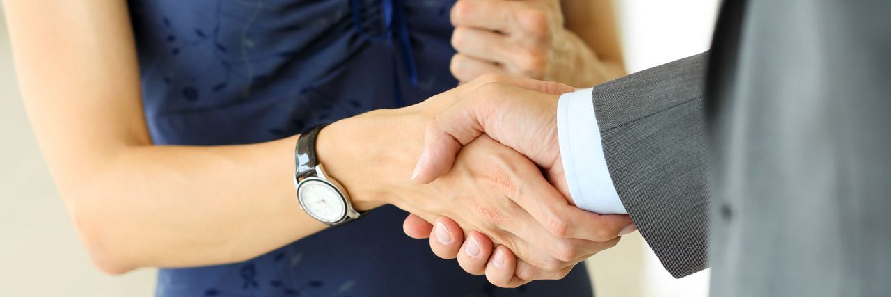 Businessman,And,Woman,Shake,Hands,As,Hello,In,Office,Closeup.
